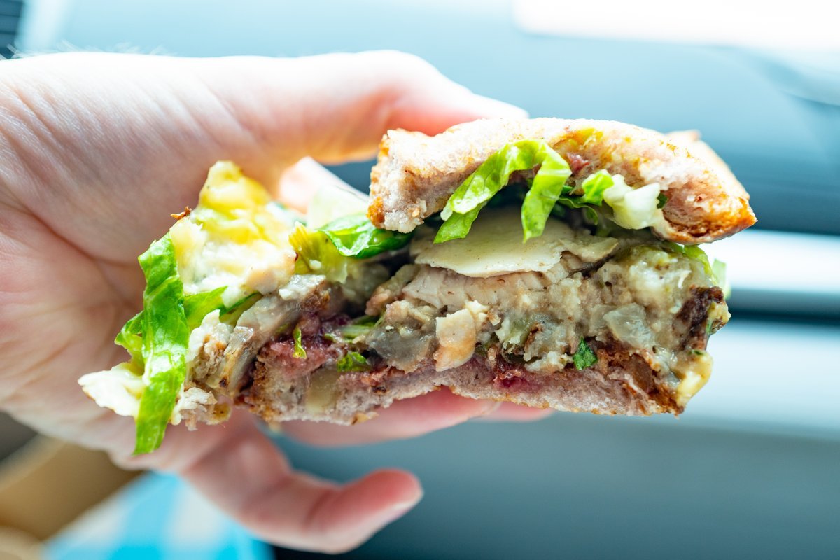 Persons hand holding holiday Thanksgiving sandwich with turkey and stuffing at Mendocino Farms restaurant, San Ramon, California, November 19, 2021. Photo courtesy Sftm.